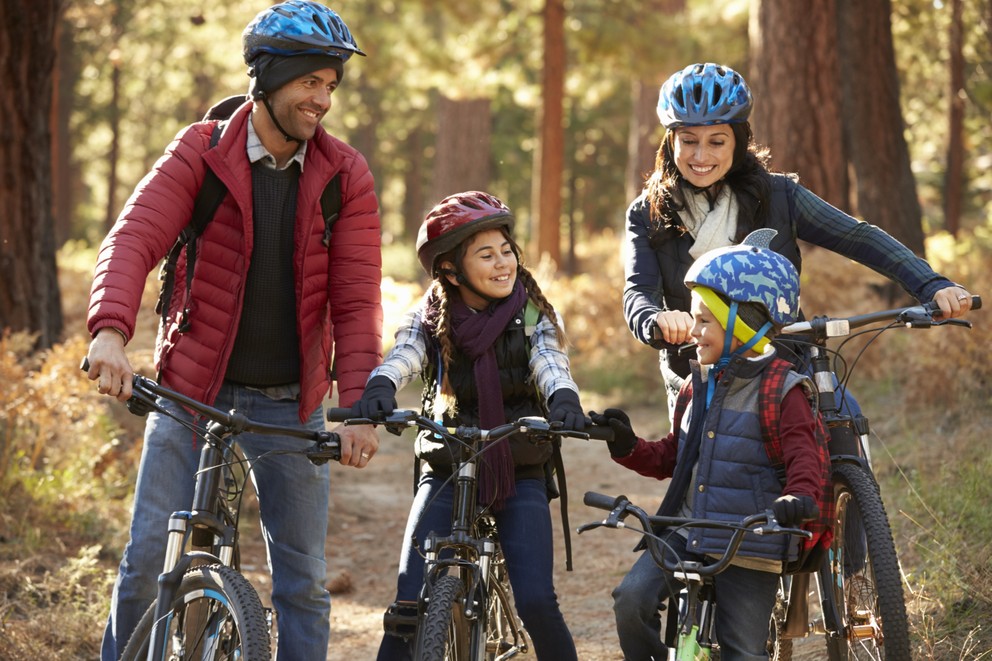 family biking through the woods