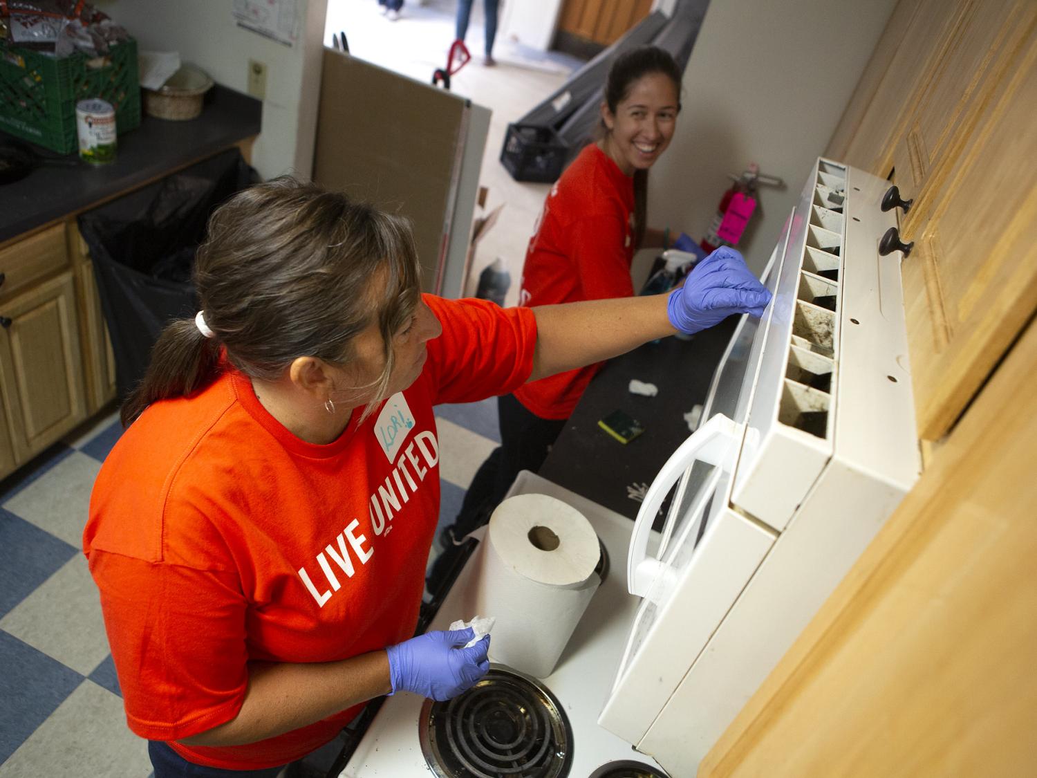 Lori Delbo, left, and Angela Comis, both of Penn State Health Milton S. Hershey Medical Center, help clean the kitchen of a residential apartment of the YWCA of Greater Harrisburg during the 2019 United Way Day of Caring. (NOTE: This photo was taken prior to enactment of safety protocols related to COVID-19.) Credit: Penn State Health. All Rights Reserved.