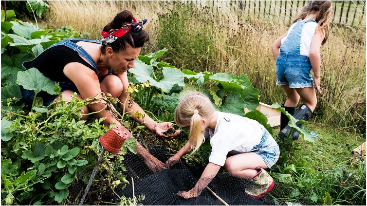 Woman with two little girls gardening