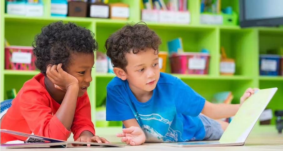 Two children looking at an open book.