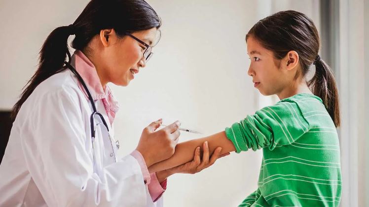 Doctor administering a shot to a child.